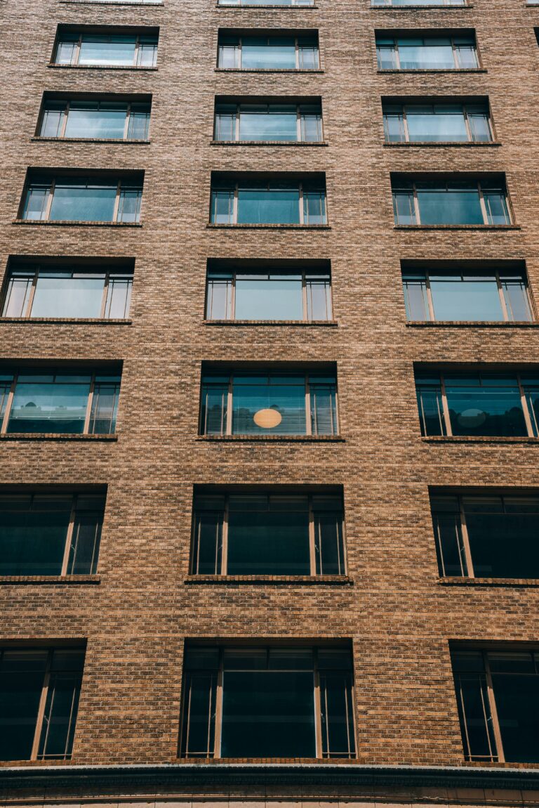 Low angle view of a brick residential building facade, highlighting its symmetry and urban aesthetics.